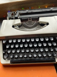 a typewriter sitting on top of an orange table